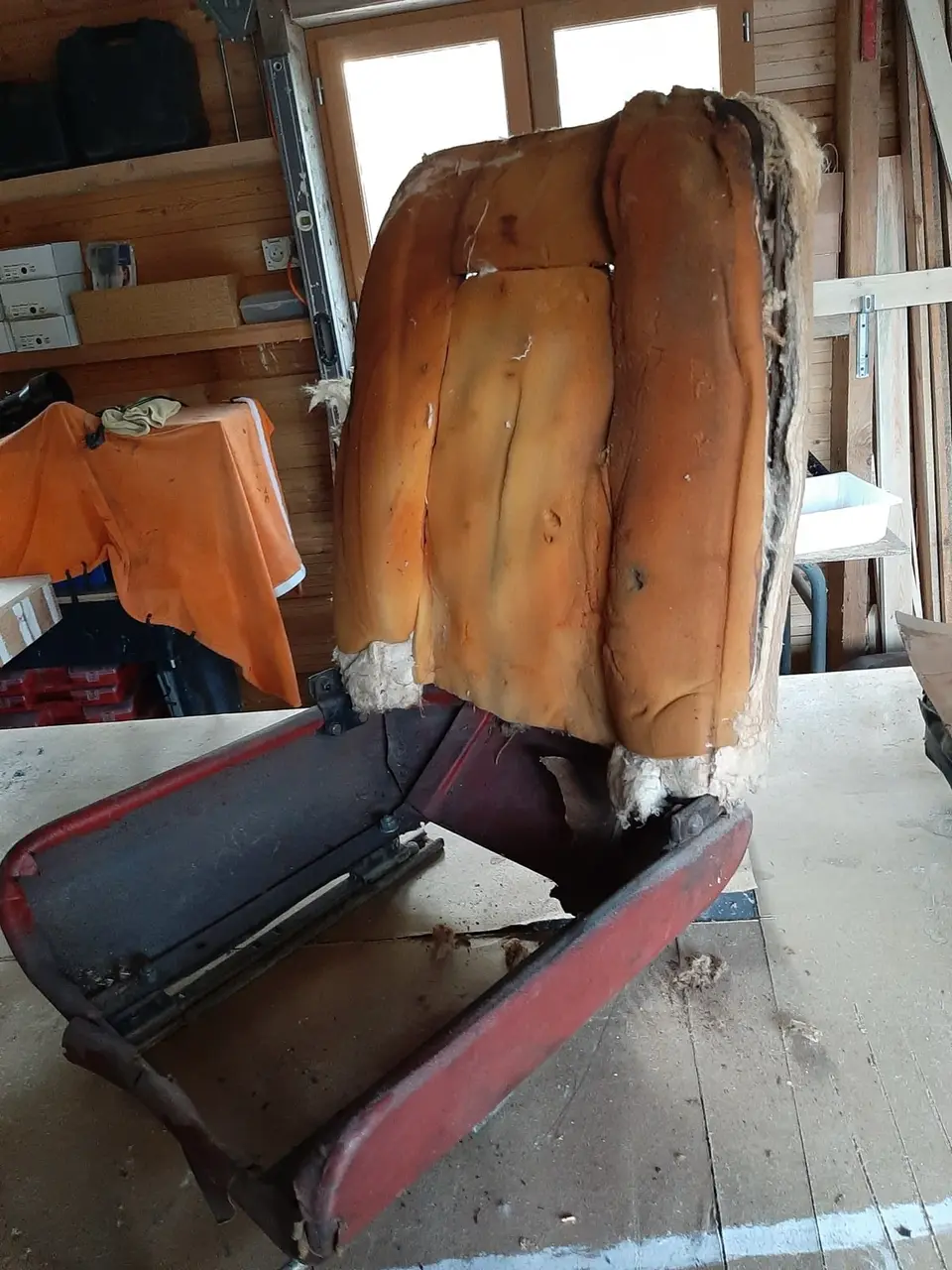 Siège rouge de véhicule ancien avant restauration, garnissage affaissé